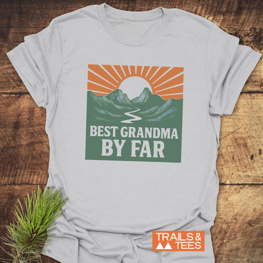 Light-gray Best Grandma By Far T-shirt with a sun and mountains graphic, laid on wood. Crafted from soft, ring-spun cotton.