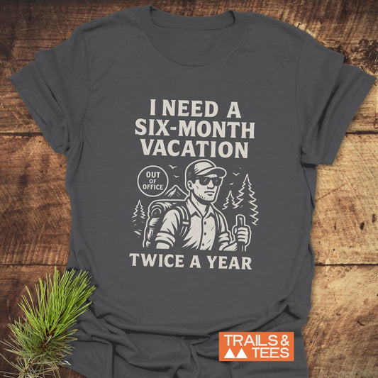 Six-Month Vacation T-Shirt featuring a vintage hiker illustration with slogan, crafted from soft cotton, ideal for outdoor enthusiasts, includes Trails & Tees logo.
