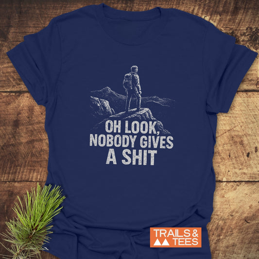 Oh Look! T-Shirt featuring a backpacker graphic and humorous caption, with “TRAILS & TEES” logo. Made from soft, durable cotton for outdoor enthusiasts.