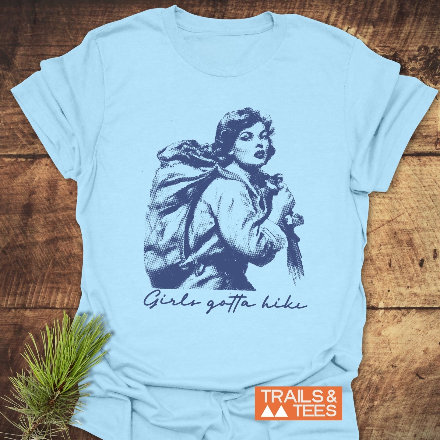 Girls Gotta Hike T-Shirt featuring a vintage hiker illustration and slogan, crafted from lightweight ring-spun cotton for comfort and durability, perfect for outdoor enthusiasts.