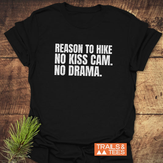 Reason To Hike: No Kiss Cam T-Shirt on wood surface, featuring bold white text. Includes Trails & Tees logo. Made from lightweight, durable cotton.