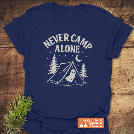 Never Camp Alone T-Shirt featuring a ghostly camping scene with pine trees and stars, crafted from soft ring-spun cotton for comfort and durability.