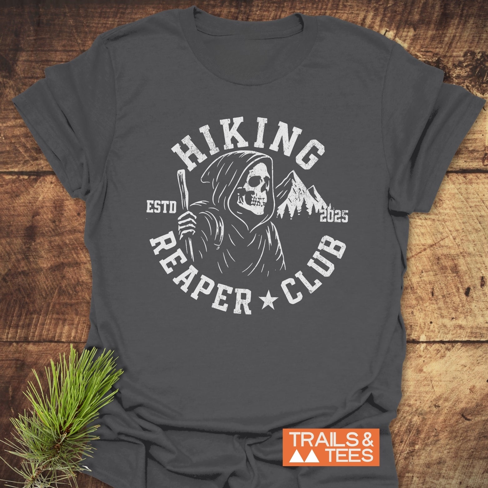 Hiking Reaper Club T-Shirt featuring a Grim Reaper graphic with hiking staff and mountains, crafted from soft cotton for comfort and durability.
