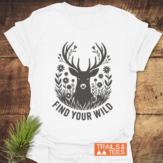 Find Your Wild T-Shirt featuring a stylized deer with antlers merging into twigs and hearts, slogan beneath, and rustic pine sprig accent.