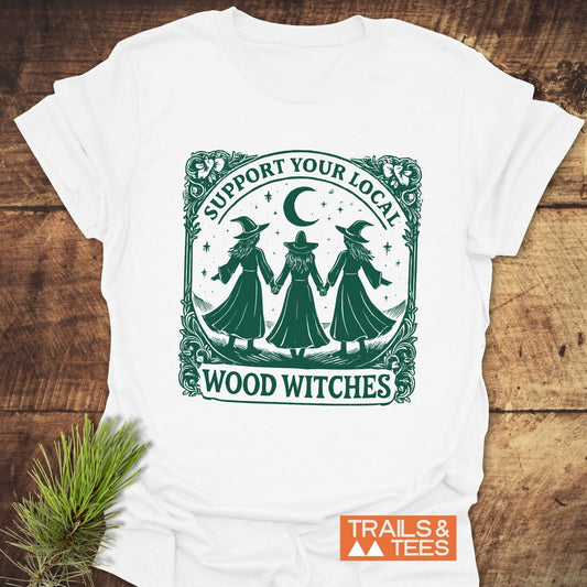 Copy of Take A Hike Human T-Shirt featuring three witches illustration, SUPPORT YOUR LOCAL WOOD WITCHES slogan, on soft, trail-comfort cotton by Trails & Tees.