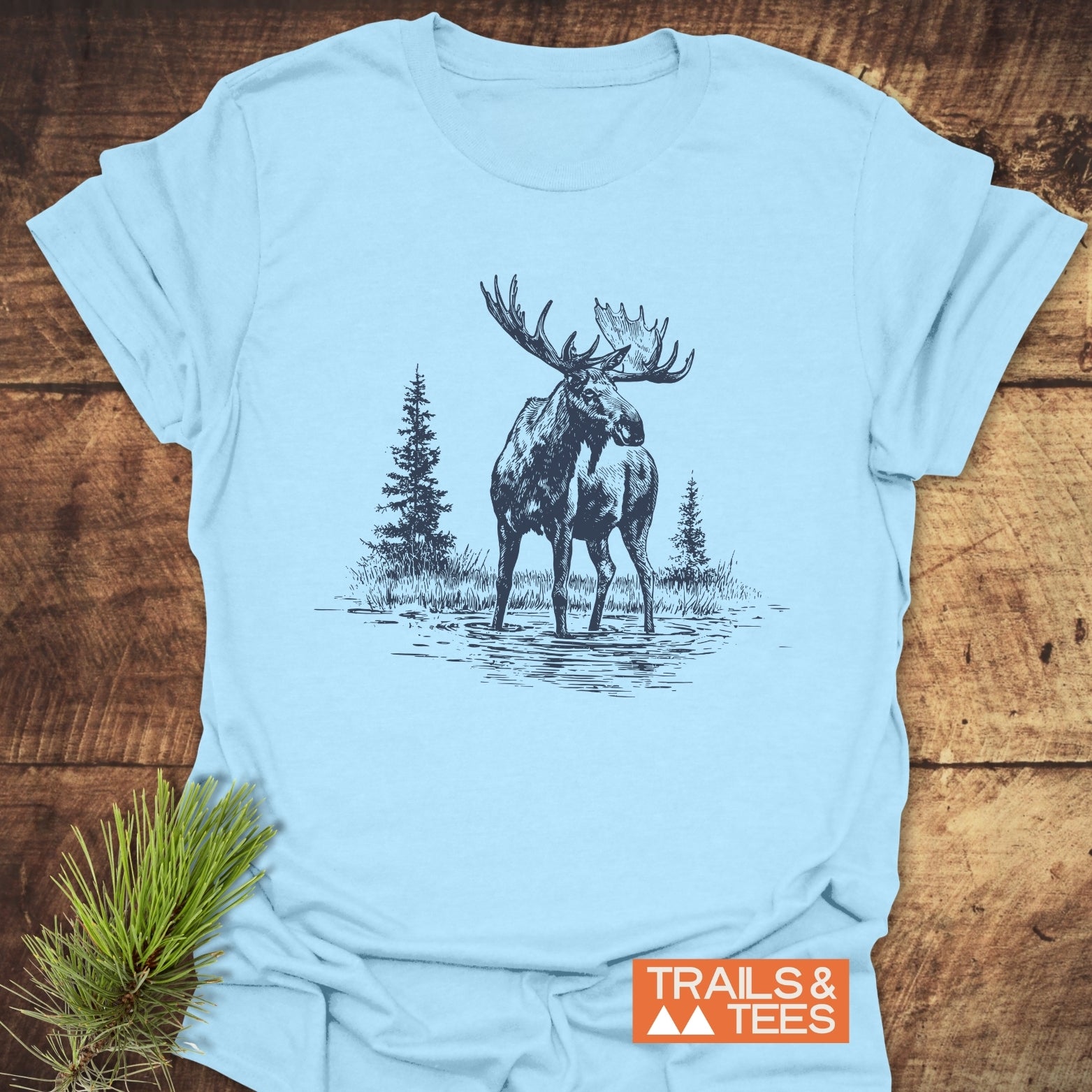Moose T-Shirt with a sketch of a bull moose in water, crafted from soft cotton for comfort and durability, featuring the TRAILS & TEES logo.