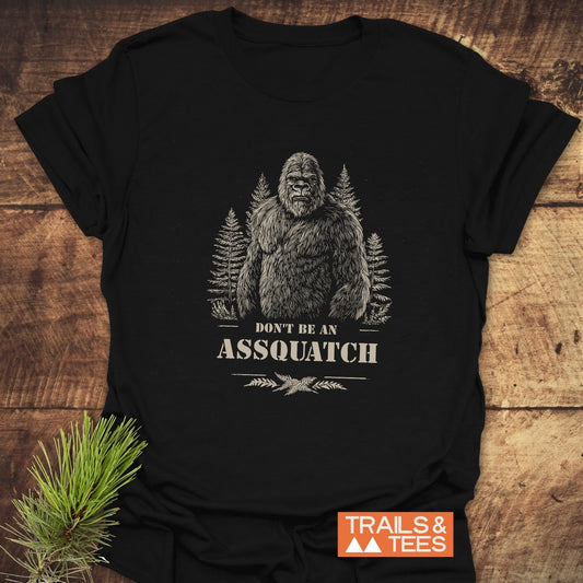 Assquatch T-Shirt featuring Bigfoot illustration and DON'T BE AN ASSQUATCH caption, crafted from soft cotton, showcasing durability and comfort for outdoor enthusiasts.