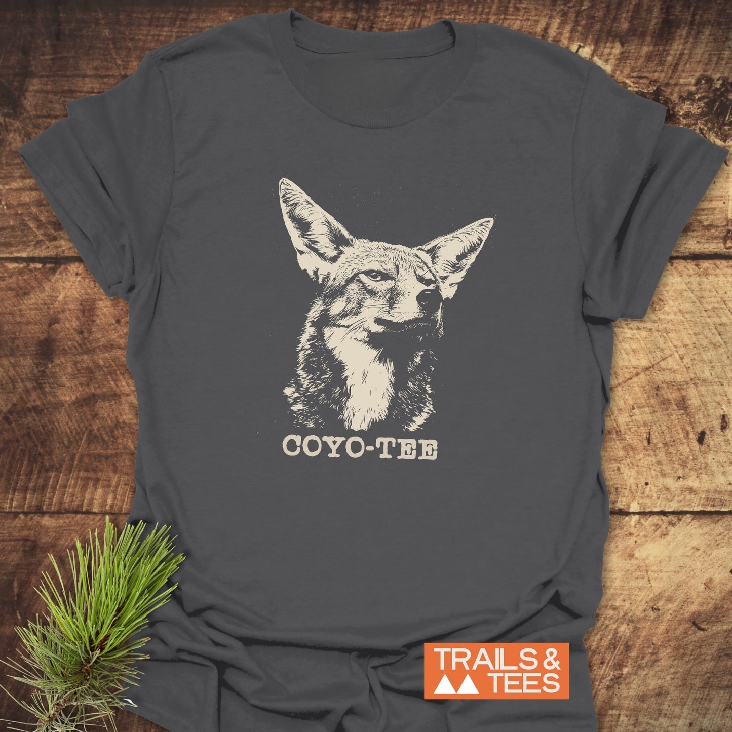 Coyo-Tee T-Shirt featuring a stylized coyote head and COYO-TEE caption, displayed with Trails & Tees logo, exemplifies outdoor-inspired, comfortable, durable design.
