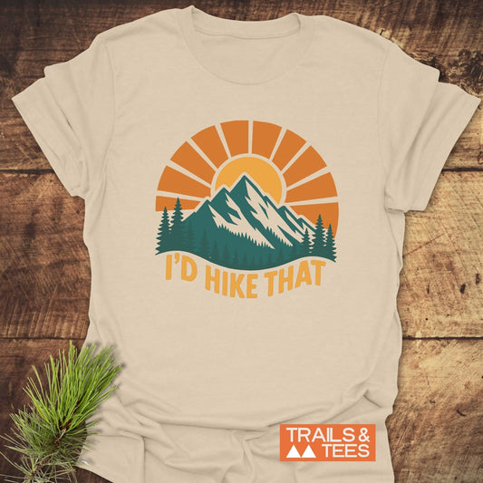 I'd Hike That T-Shirt with retro mountain graphic and slogan, crafted from soft cotton for comfort; ideal for outdoor enthusiasts. Durable, pre-shrunk, and eco-friendly design.