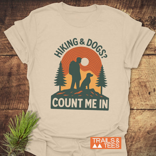 Hiking And Dogs T-Shirt featuring a retro graphic of a hiker, dog, and trees with HIKING & DOGS? COUNT ME IN. Crafted from ring-spun cotton.