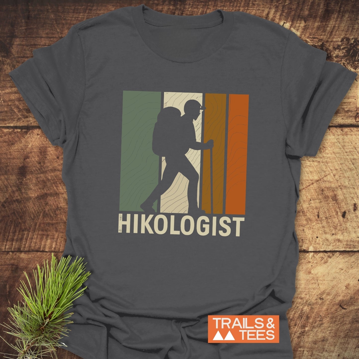 Hikologist T-Shirt featuring a hiker silhouette with earth-tone stripes, crafted from soft ring-spun cotton, ideal for outdoor enthusiasts.