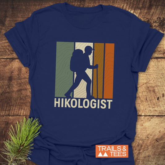 Hikologist T-Shirt featuring a retro hiker graphic with earth-tone stripes and HIKOLOGIST text, crafted from soft, pre-shrunk cotton for comfort and durability.