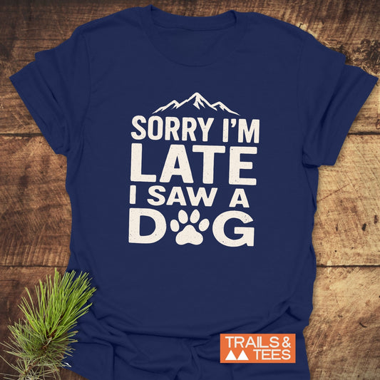 Navy-blue I Saw A Dog T-shirt with white graphic, mountain silhouette, and paw print detail. Includes TRAILS & TEES label, enhancing the outdoorsy theme.