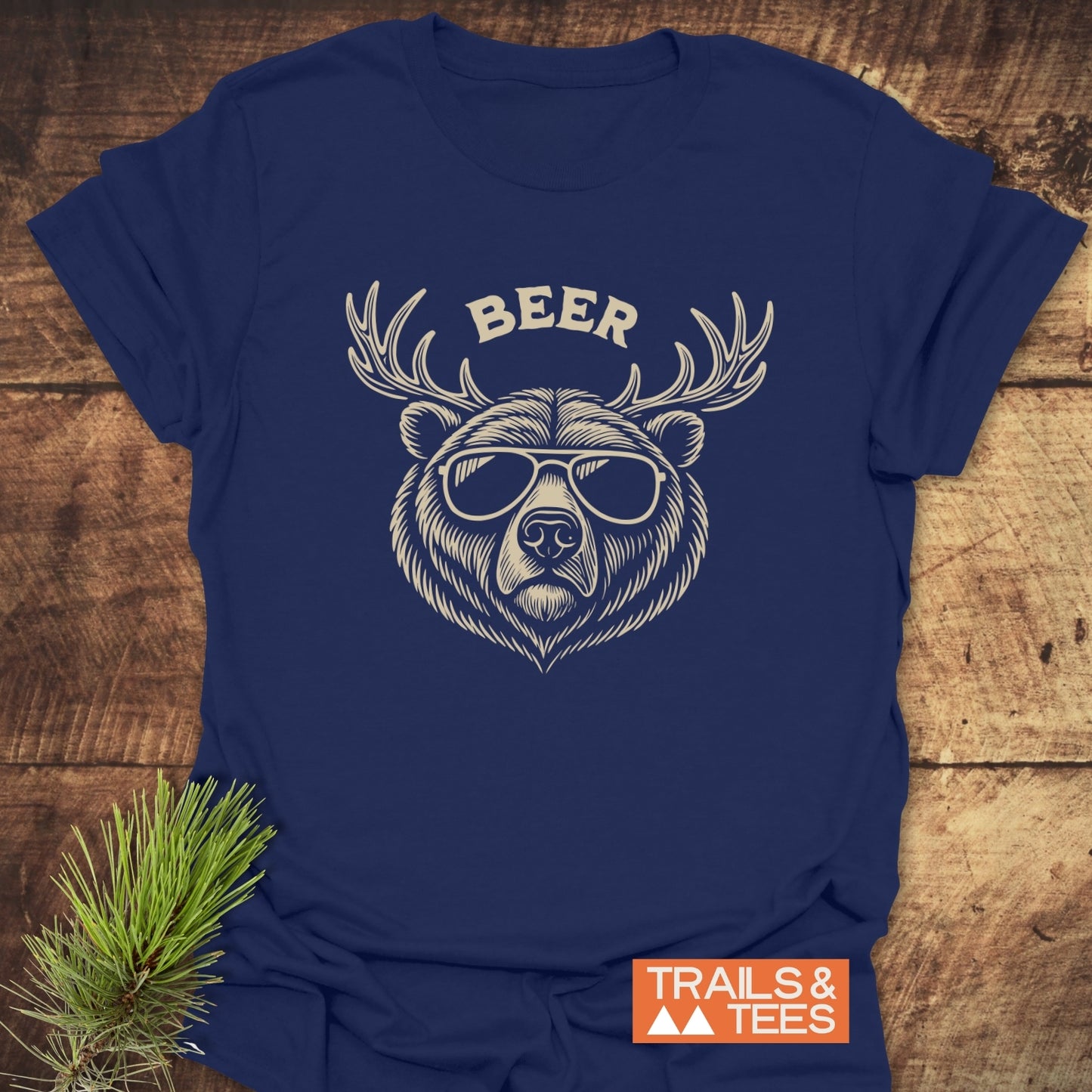 Beer Funny T-Shirt featuring a bear with sunglasses and antlers graphic. Made from soft cotton, perfect for outdoor adventures. Trails & Tees logo visible.