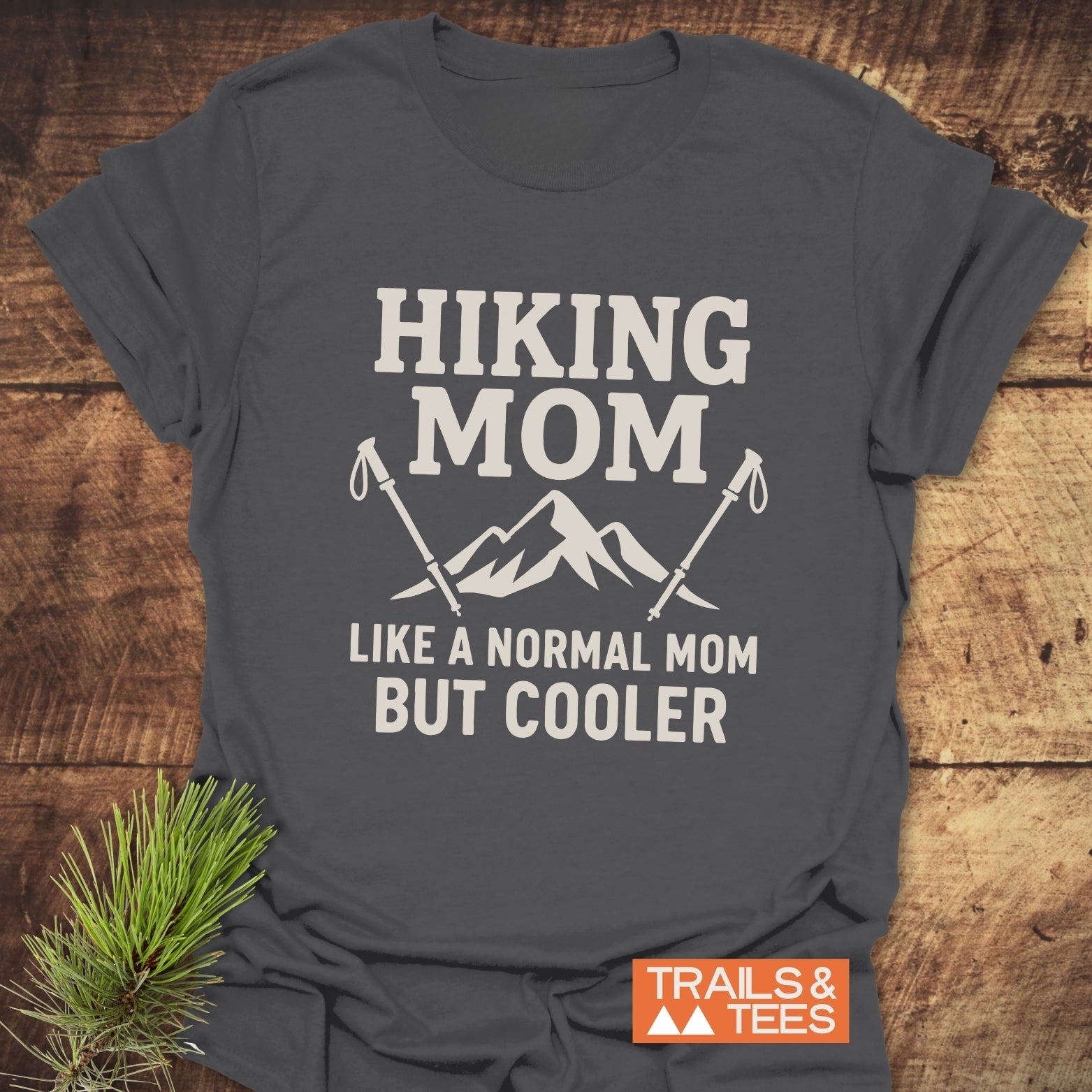 Dark-gray Hiking Mom T-Shirt with mountain graphic and text, laid flat. Made of soft ring-spun cotton, pre-shrunk for fit, featuring durable prints.
