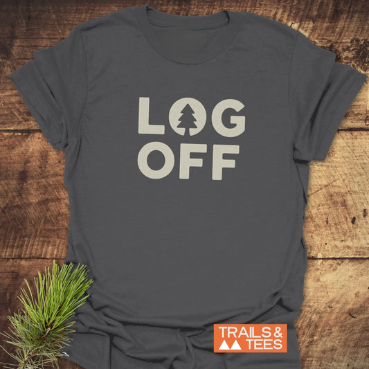 Log Off T-Shirt displaying LOG OFF with tree design, laid on wood. Features durable print on soft, lightweight cotton, ideal for outdoor enthusiasts.