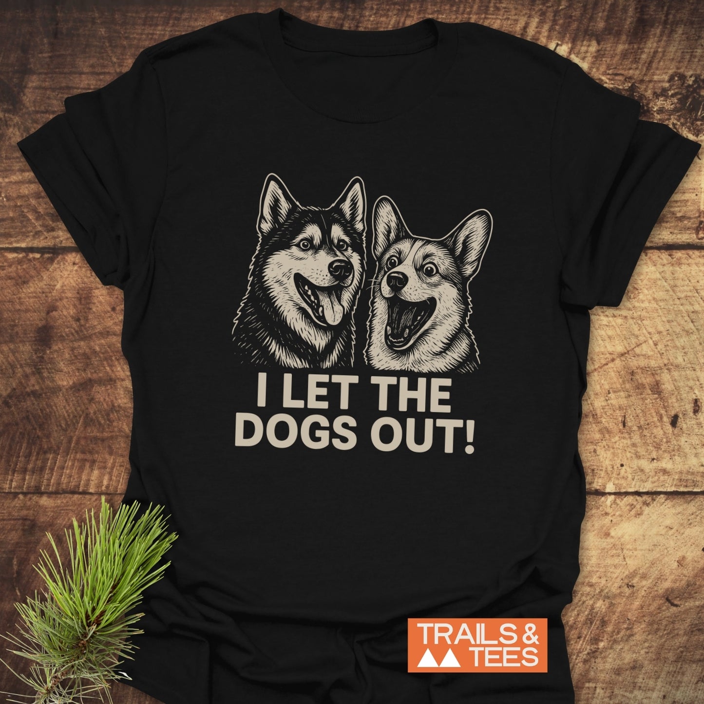 I Let The Dogs Out T-Shirt featuring two happy dog portraits, crafted from soft ring-spun cotton, with durable prints and the Trails & Tees logo.