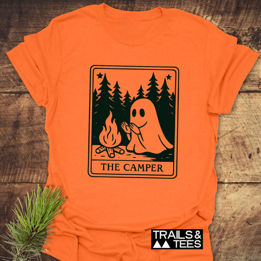 The Camper Retro Tarot T-Shirt featuring a cartoon ghost by a campfire, crafted from soft cotton with durable prints, and Trails & Tees branding.
