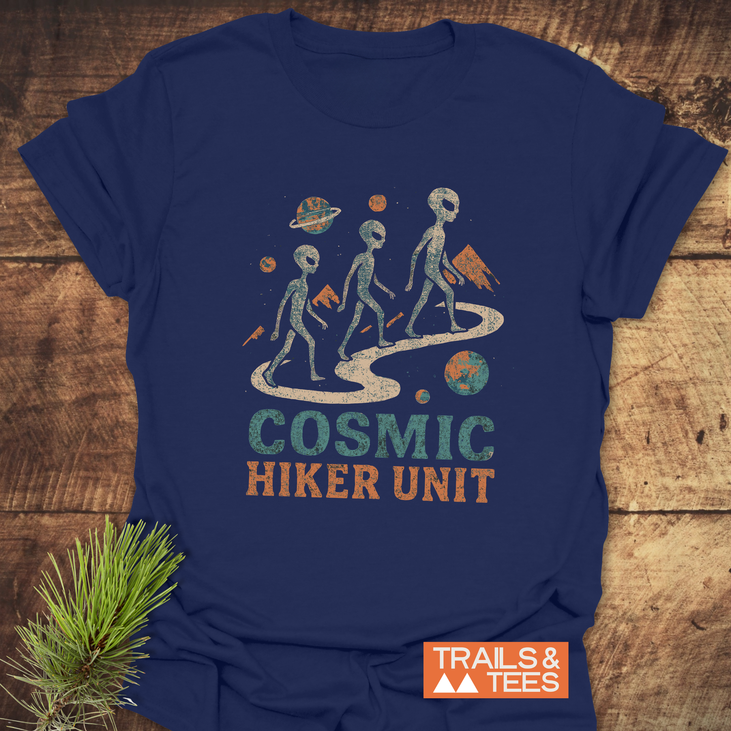 Cosmic Hiker Unit T-Shirt featuring alien silhouettes and planets; made from soft, durable cotton, perfect for outdoor enthusiasts. Includes Trails & Tees logo.