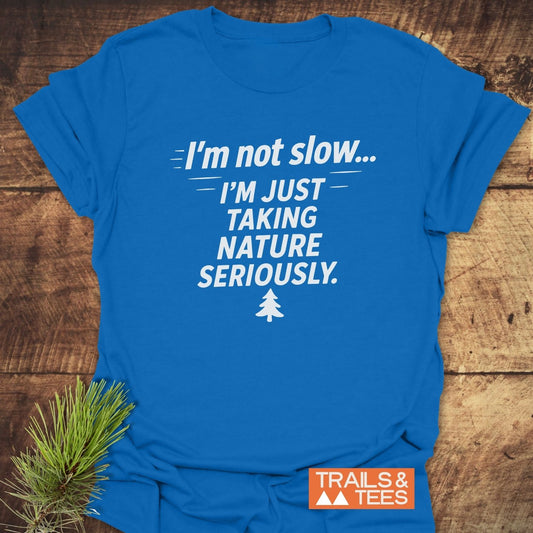 Royal-blue I'm Not Slow... Funny T-Shirt with slogan and pine tree icon on wood, showcasing comfort and durability, perfect for outdoor enthusiasts.