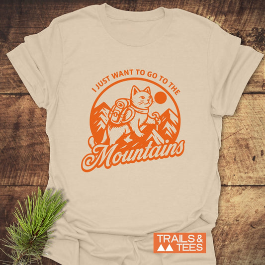 Mountain Kitty T-Shirt featuring a bright orange logo of a cat hiking, printed on a light-tan cotton tee. Perfect for outdoor enthusiasts and adventure lovers.