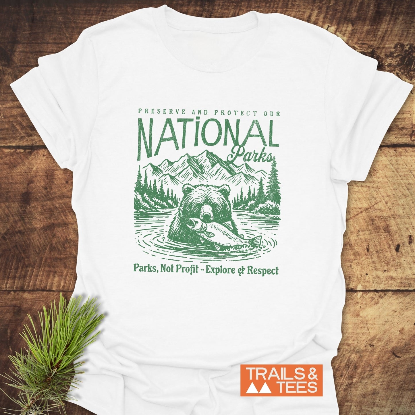 National Parks T-Shirt featuring a bear design with conservation slogans, laid on wood; soft, ring-spun cotton, pre-shrunk, durable print, by Trails & Tees.