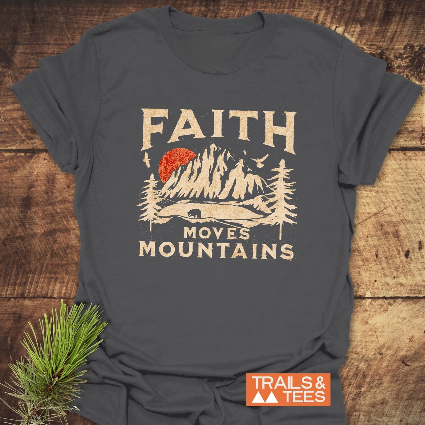 Faith Moves Mountains T-Shirt featuring vintage-style print with mountains, sun, and bear. Made of soft cotton, pre-shrunk, durable, and designed for outdoor enthusiasts.