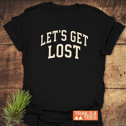 Let's Get Lost T-Shirt featuring “LET’S GET LOST” slogan, Trails & Tees logo, styled on wooden planks with pine sprig, crafted from soft, lightweight cotton.