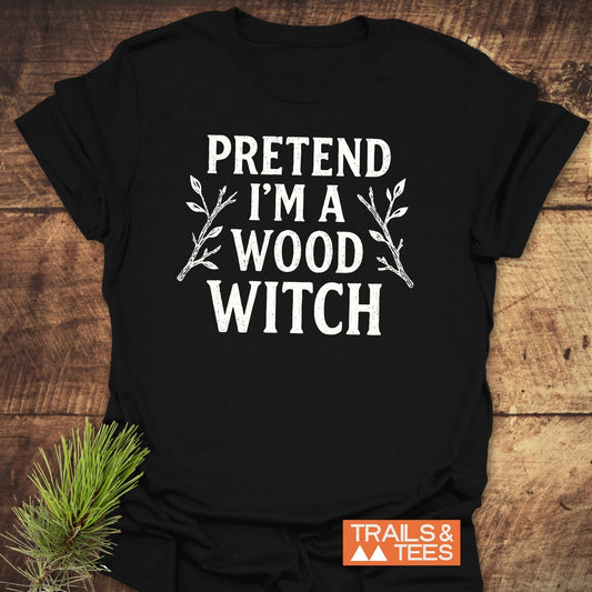 Wood Witch Funny T-Shirt with PRETEND I'M A WOOD WITCH text, twig illustrations, and TRAILS & TEES logo, showcasing comfort and durability.