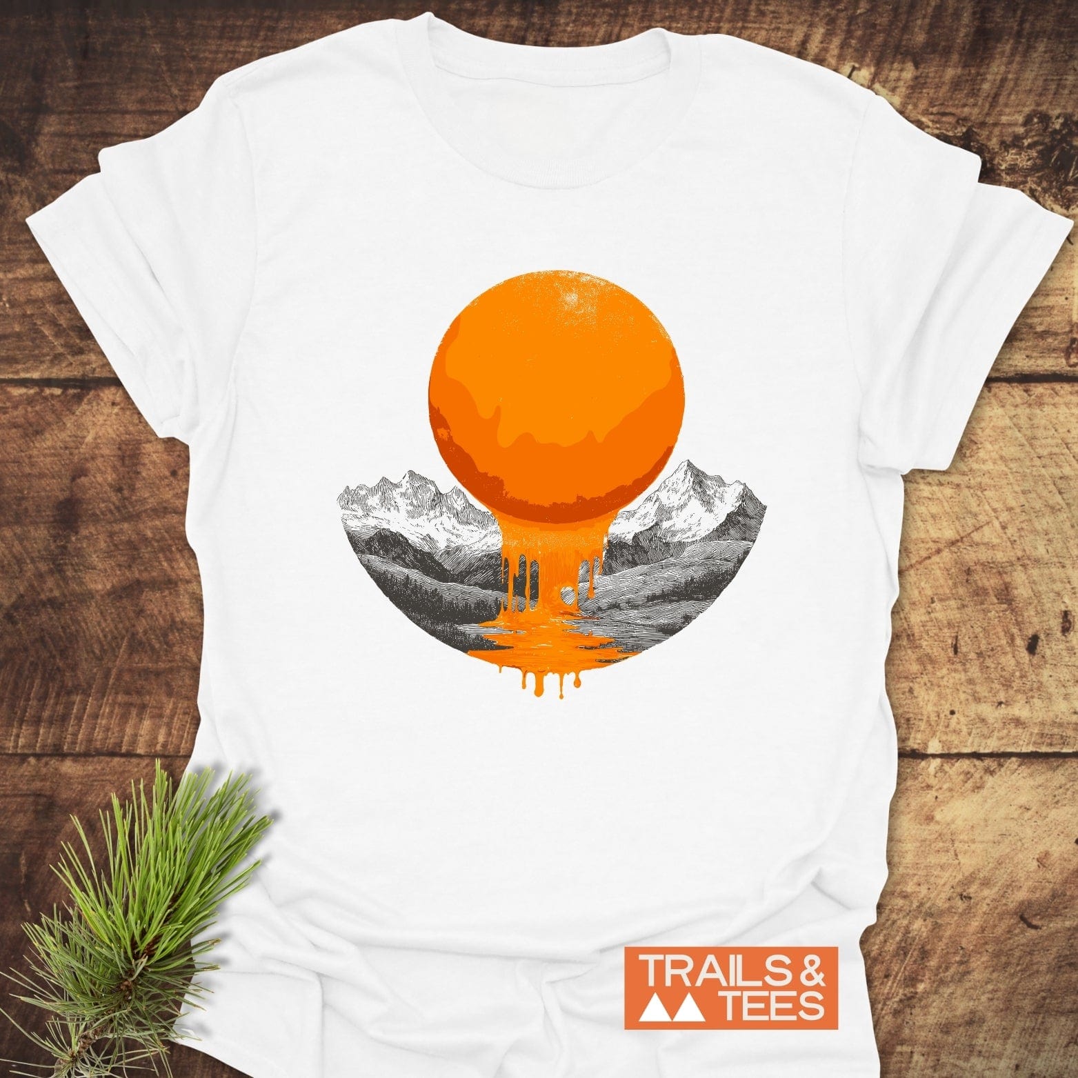 Melting Sun T-Shirt featuring a graphic of a melting sun over a mountain valley, crafted from soft cotton for comfort and durability, with TRAILS & TEES logo.