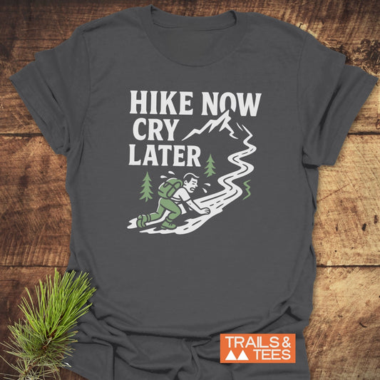 Cry Later Funny T-Shirt featuring a cartoon hiker and slogan, crafted from lightweight cotton for comfort and durability, with “TRAILS & TEES” logo.