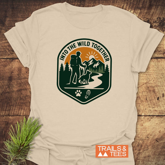 Into The Wild T-Shirt featuring a hiker and dog graphic, with durable prints and eco-friendly production. Perfect for outdoor enthusiasts.