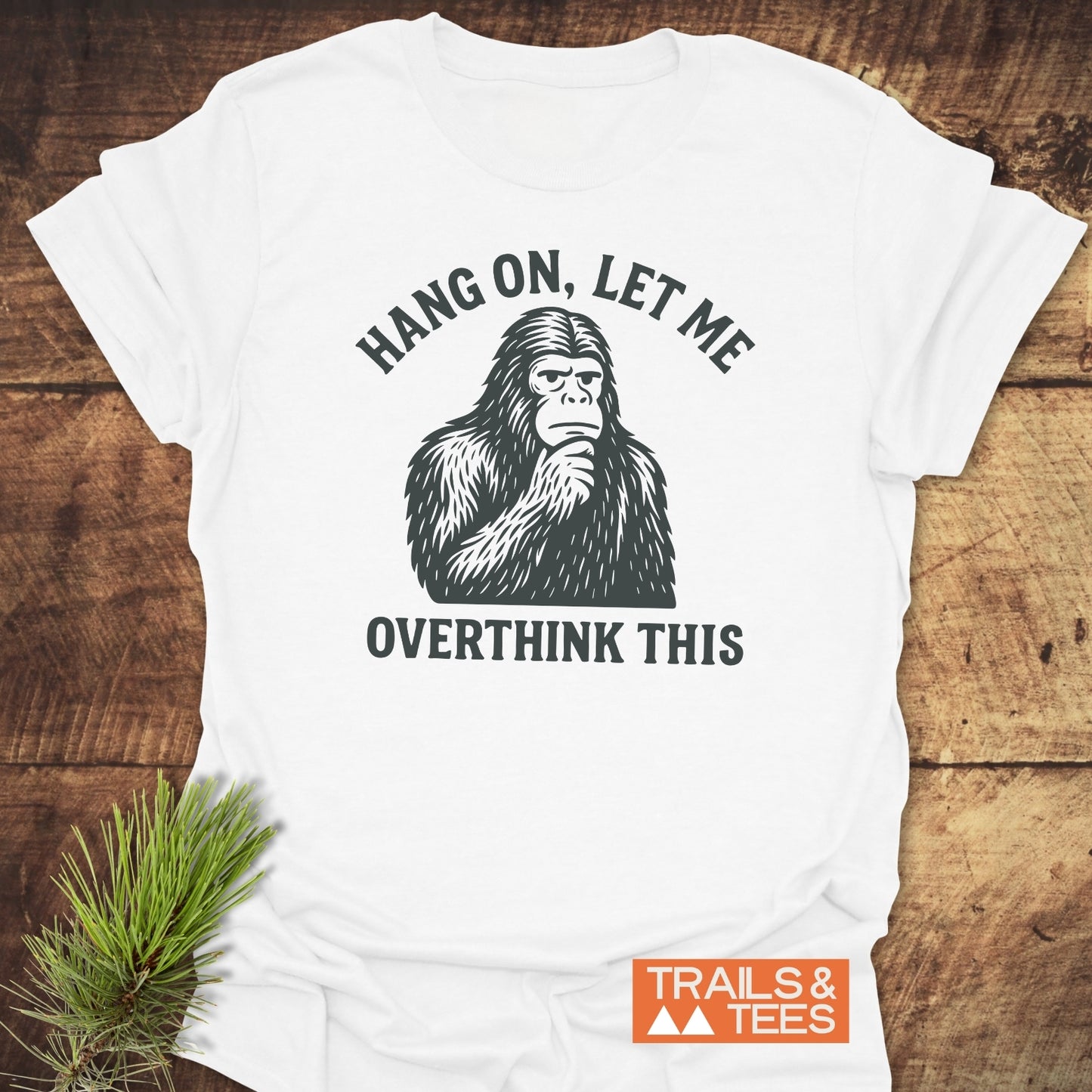 Bigfoot Overthinking T-Shirt featuring a thoughtful creature illustration with HANG ON, LET ME OVERTHINK THIS text, on soft cotton, emphasizing comfort and durability.