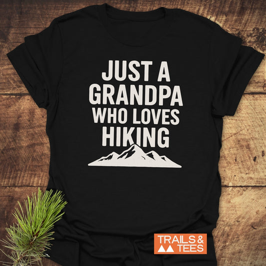 Black Hiking Grandpa T-Shirt with white mountain graphic, showcasing text “JUST A GRANDPA WHO LOVES HIKING.” Crafted for comfort and adventure, perfect for outdoor enthusiasts.