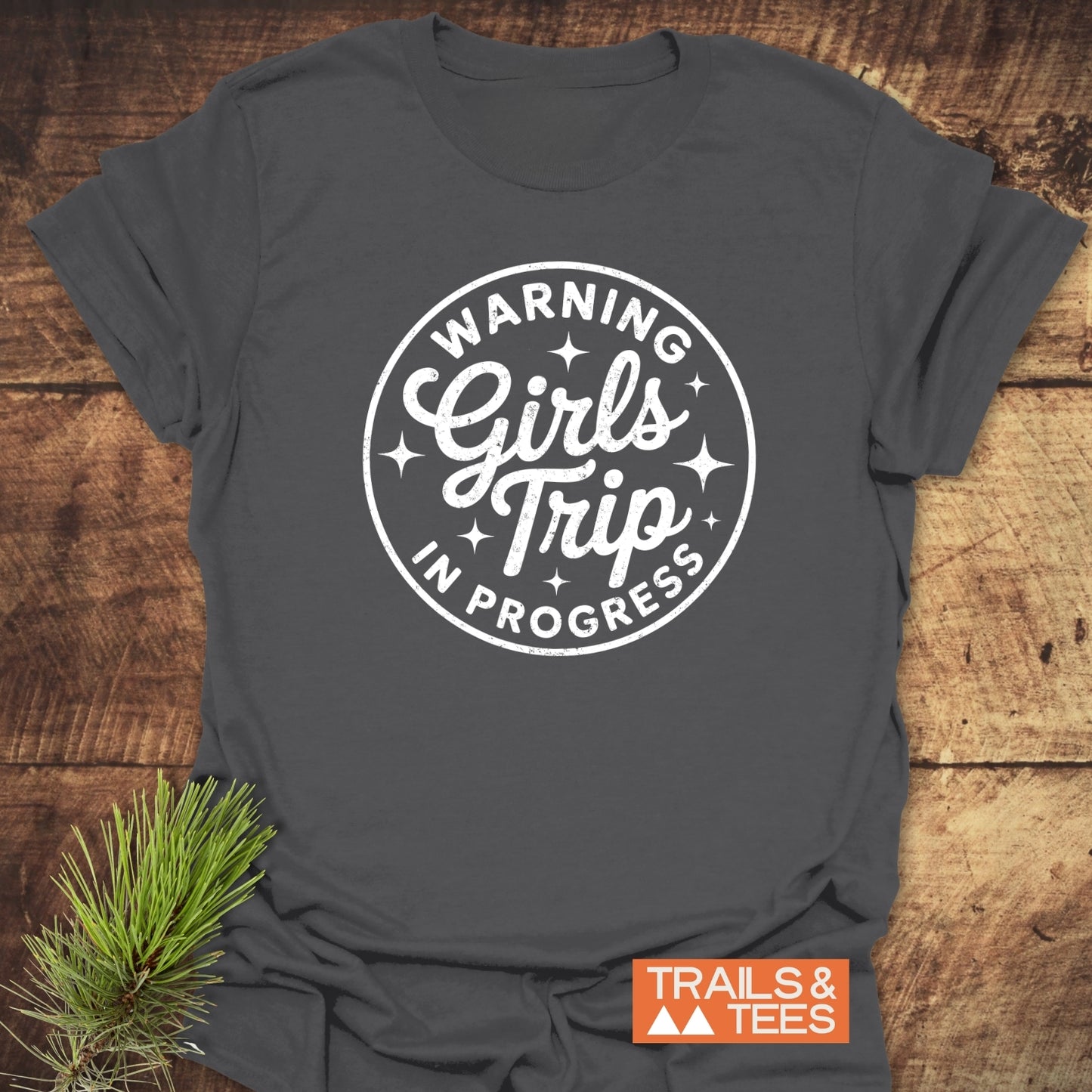 Girls Trip Hiking T-Shirt with white Girls Trip In Progress badge on heather-charcoal gray fabric, showcasing outdoor-inspired comfort and durability from Trails & Tees.