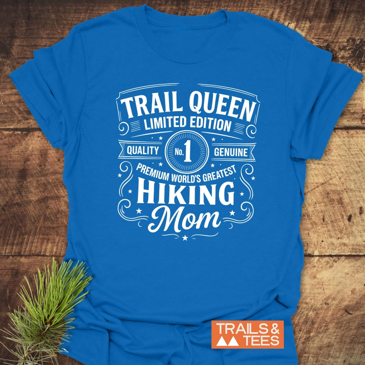 Trail Queen Mom T-Shirt featuring a white vintage-style design, laid flat on wood. Crafted from soft ring-spun cotton, ideal for outdoor adventures.