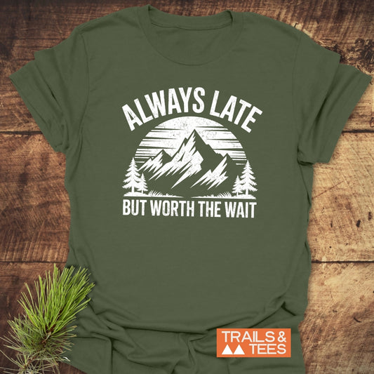 Always Late Funny T-Shirt with a mountain and pine tree graphic, slogan, and Trails & Tees logo, showcasing durable, comfort-focused design for outdoor enthusiasts.