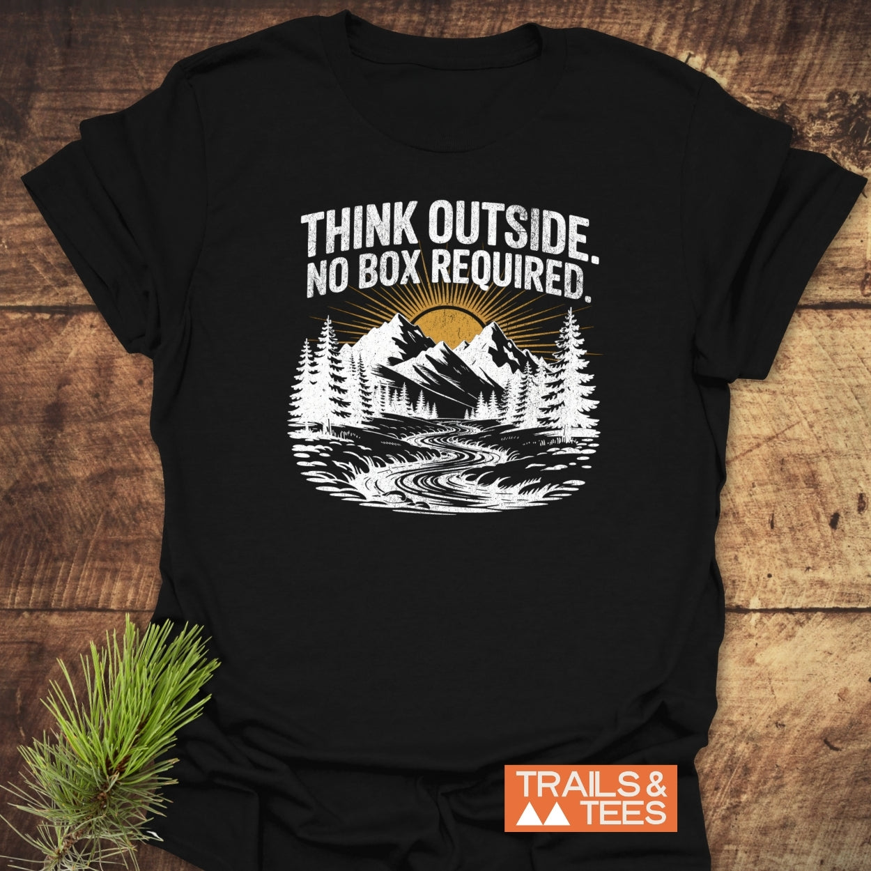 Think Outside T-Shirt with mountain graphic, slogan, and Trails & Tees logo on soft ring-spun cotton, emphasizing outdoor adventure and sustainable design.