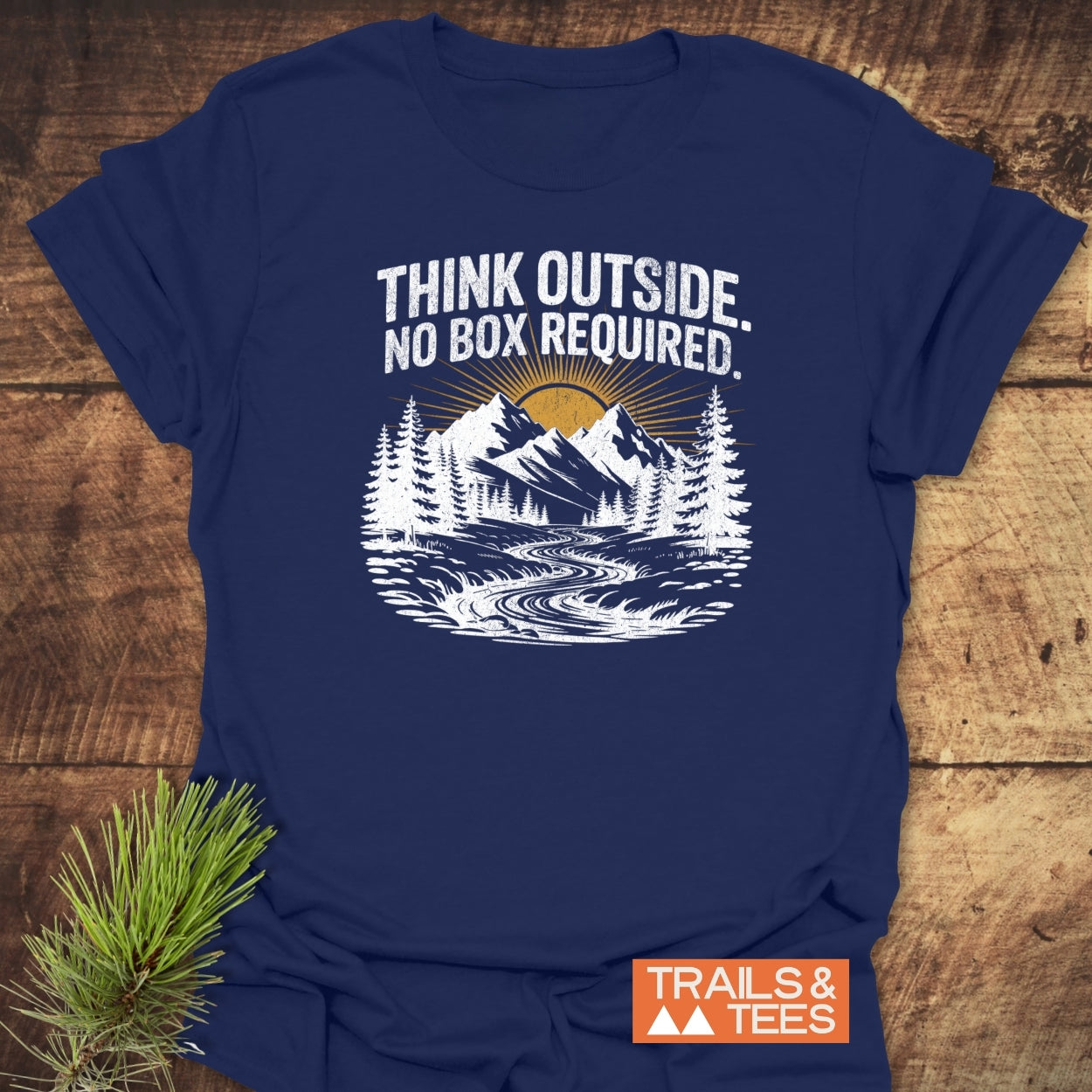 Think Outside T-Shirt featuring outdoor-themed graphic with mountains and river, crafted from soft cotton for comfort and durability, styled with a pine bough.
