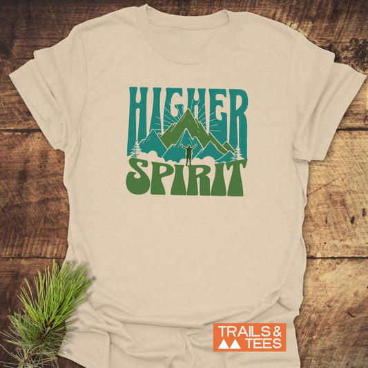 Higher Spirit T-Shirt with stylized mountain graphic and “HIGHER SPIRIT” text, laid on wood. Features soft, pre-shrunk cotton and durable print.