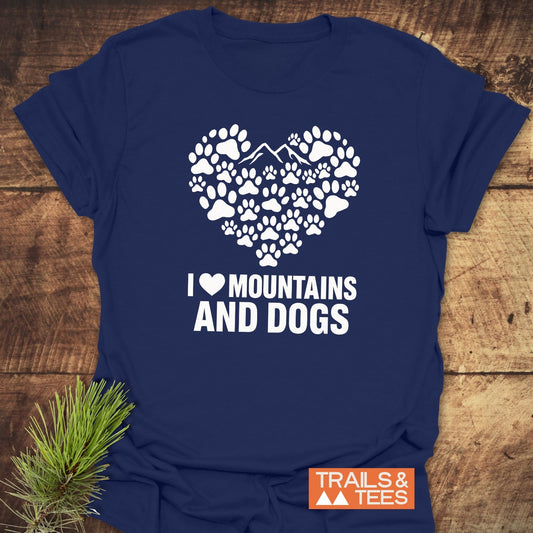 Navy-blue Paw Heart Dog Lover T-Shirt with white paw print heart design, featuring mountains and slogan, I ♥ MOUNTAINS AND DOGS, beside Trails & Tees logo.