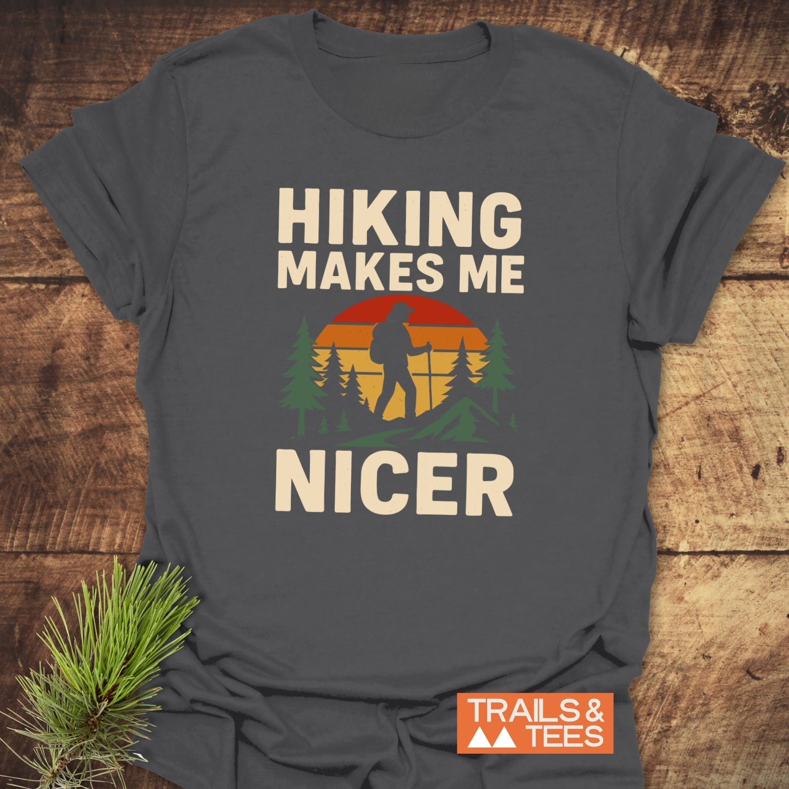 Hiking Makes Me Nicer T-Shirt with a hiker silhouette and sunset graphic; soft, ring-spun cotton, pre-shrunk for fit, durable DTF print.