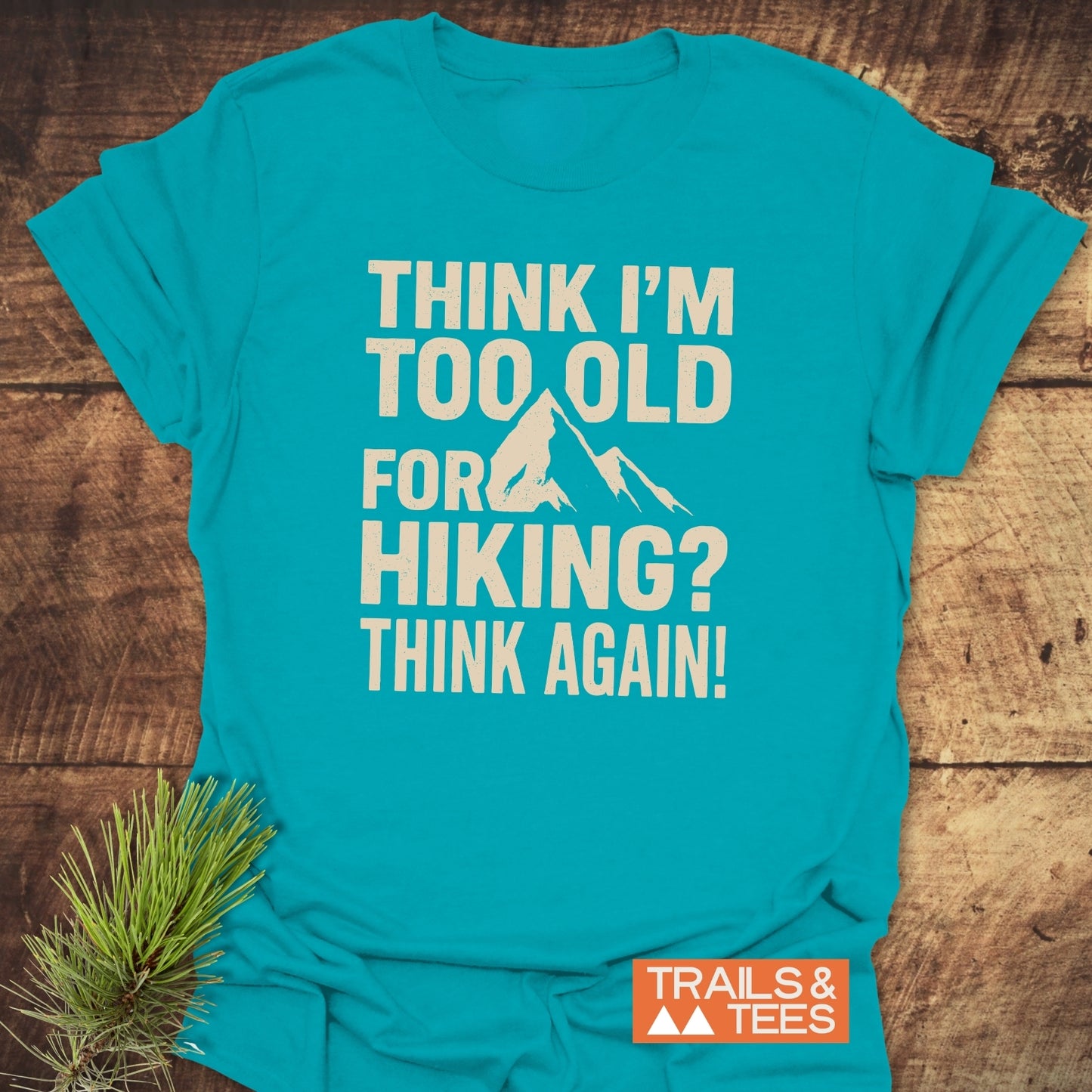 Teal Think Again Funny T-Shirt with mountain graphic and slogan, featuring TRAILS & TEES logo; crafted for comfort and durability, perfect for outdoor enthusiasts.