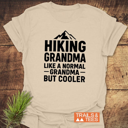 Light-colored Hiking Grandma T-shirt with mountain graphic, bold text, and TRAILS & TEES logo, showcasing adventure-ready design and soft ring-spun cotton.