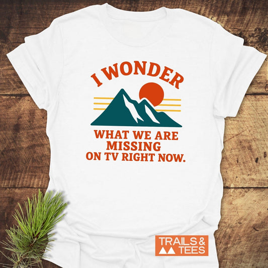 What's On TV Funny T-Shirt with mountain silhouette, sun graphic, and bold text. Crafted from soft cotton, offering comfort and durability for outdoor enthusiasts.