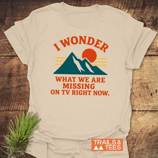 What's On TV Funny T-Shirt featuring teal mountains, a red-orange sun, and bold text. Crafted from soft cotton for outdoor enthusiasts, emphasizing comfort and adventure.