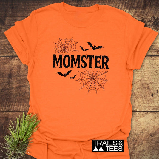 Momster Halloween T-Shirt with spooky font, bats, and spiderwebs. Soft, durable ring-spun cotton for comfort and adventure. Trails & Tees logo present.