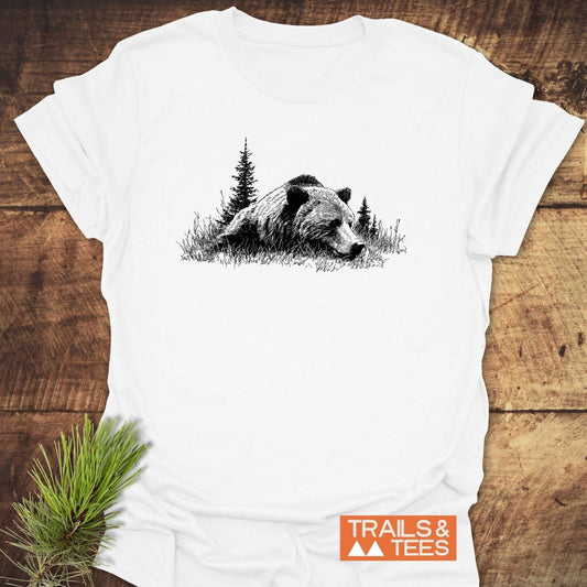 Relaxing Grizzly T-Shirt features a black bear design on soft, ring-spun cotton, highlighting outdoor adventure with a small TRAILS & TEES logo.