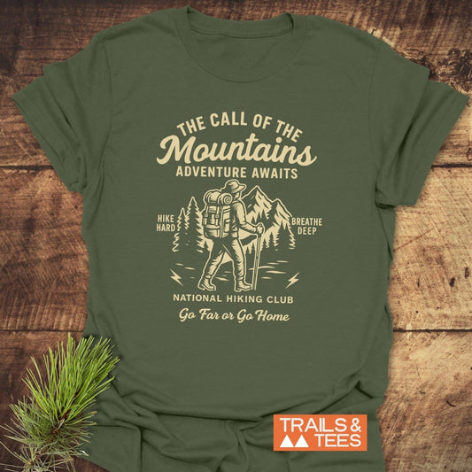 Call Of The Mountains T-Shirt: Olive-green with vintage hiking graphic and motivational text, crafted from soft cotton for comfort and adventure-ready style.