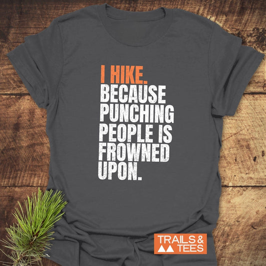 Charcoal-gray I Hike. Funny T-Shirt with bold slogan, crafted from soft cotton, featuring a TRAILS & TEES logo, styled with pine sprig.